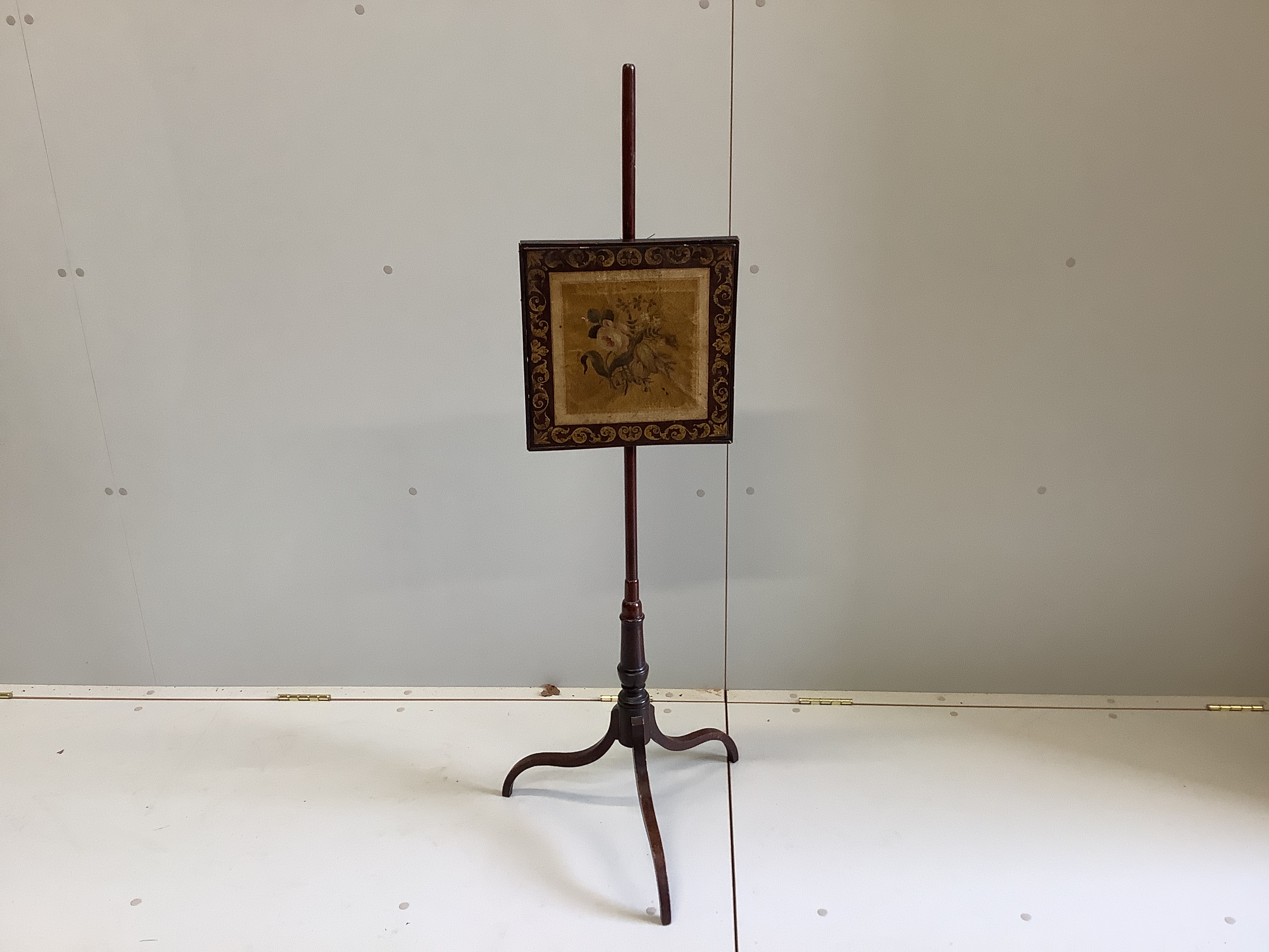 A George III mahogany polescreen with painted canvas panel, height 125cm